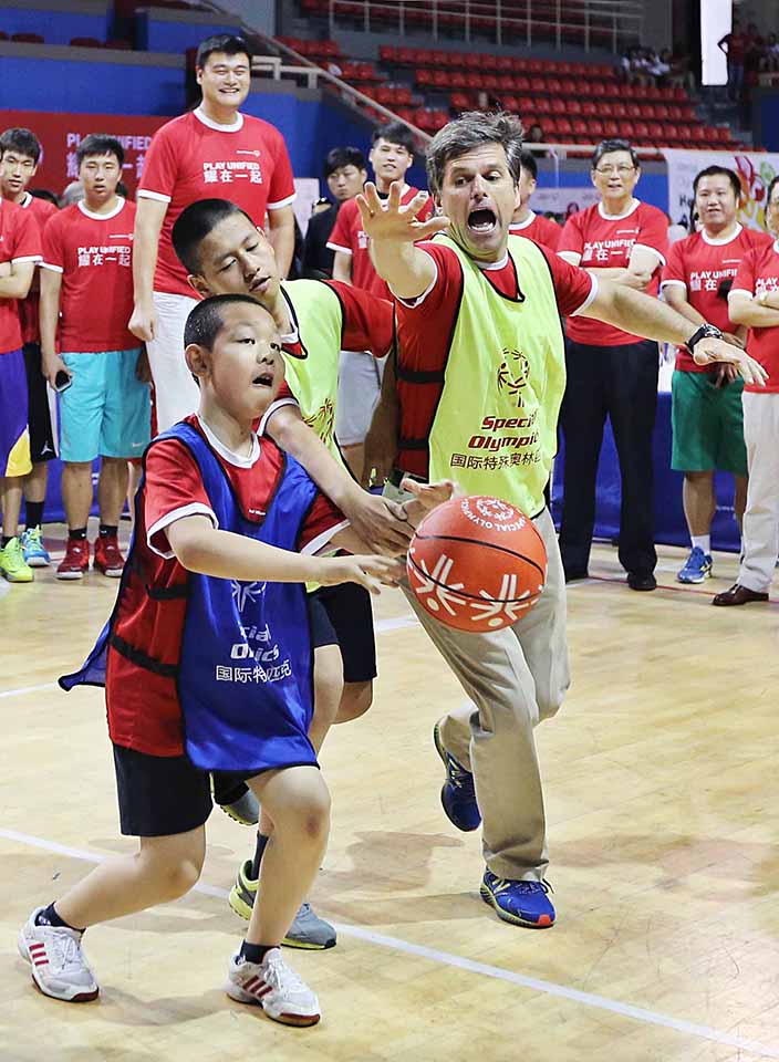 “耀在一起”融合运动会 国际特殊奥林匹克主席蒂姆·施莱佛（右）与特奥运动员在篮球比赛中